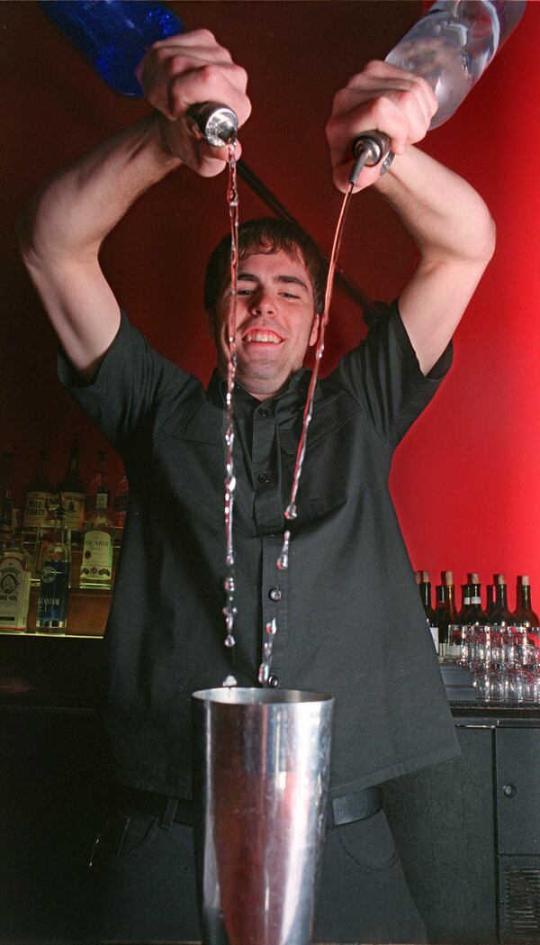 Bartender Steve Nueroth doing his best 'Tom Cruise in the movie Cocktail' imitation behind the bar at downtown Mumbo Jumbo in 1999. / AJC file photo