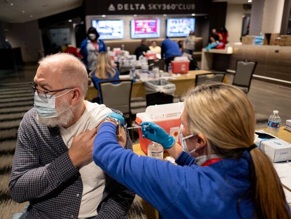 Ronald Murphey looks away as he receives his  COVID-19 vaccine during an event in January for Fulton County School employees and their spouses who are 65 and older. Gov. Brian Kemp is facing pressure from critics to move teachers higher up on the priority list for the vaccine. (Photo: Ben Gray for The Atlanta Journal-Constitution)