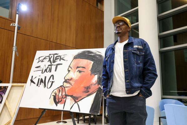 Artist Dakoro Edwards reacts after creating a live painting depicting Dexter King at Sandy Springs City Hall. The reception kicked off the City of Sandy Springs’ tribute to Black History Month. (Jason Getz / jason.getz@ajc.com)