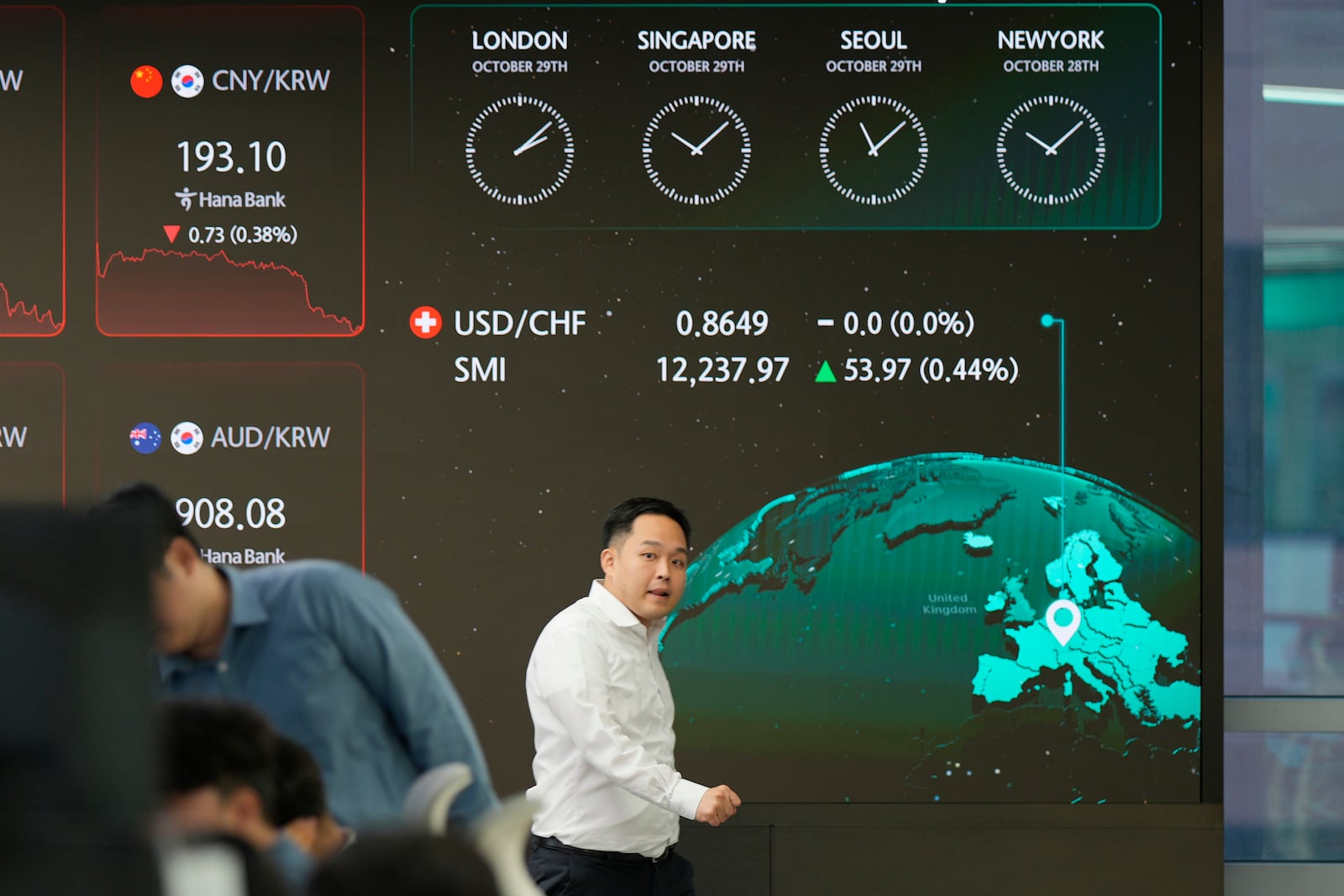 A currency trader walks by the screens showing the foreign exchange rates at a foreign exchange dealing room in Seoul, South Korea, Tuesday, Oct. 29, 2024. (AP Photo/Lee Jin-man)