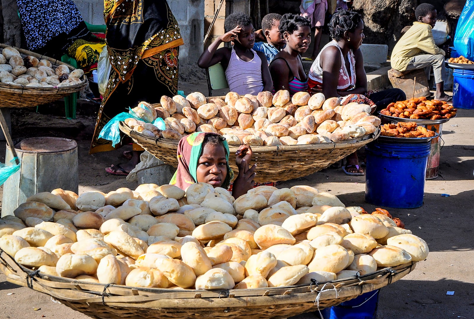 A woman sits between bread rolls in Maputo, Mozambique, Sunday, Oct. 6, 2024 ahead of elections to be held in the country. (AP Photo/Carlos Uqueio)