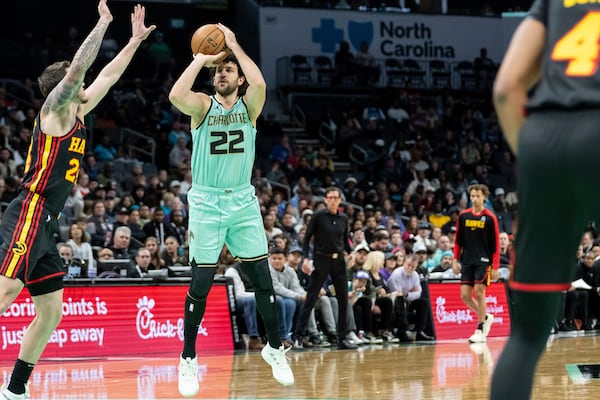 Charlotte Hornets guard Vasilije Micic (22) shoots a three point basket over Atlanta Hawks guard Garrison Mathews during the first half of an NBA basketball game, Saturday, Nov. 30, 2024, in Charlotte, N.C. (AP Photo/Matt Kelley)