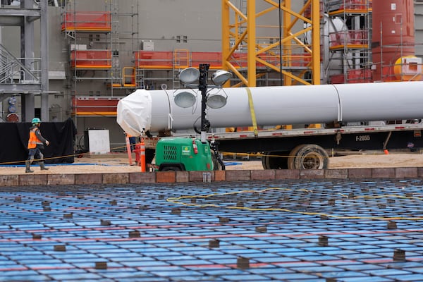 The foundation for a warehouse is visible in the foreground at Entergy's Orange County Advanced Power Station, a 1,215-megawatt facility under construction, Monday, Feb. 24, 2025, in Orange, Texas. (AP Photo/David J. Phillip)