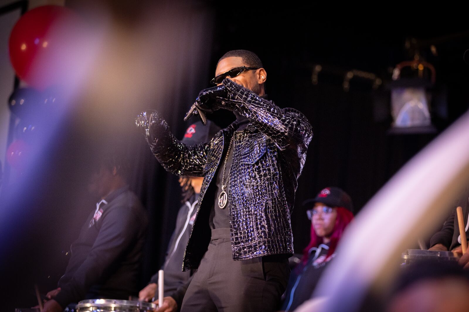 Usher appears for a homecoming rally at Clark Atlanta University in Atlanta on Wednesday, February 14, 2024, while the CAU marching band plays. Along with other honors, Amazon presented a $25,000 donation to Usher’s New Look Foundation. (Arvin Temkar / arvin.temkar@ajc.com)