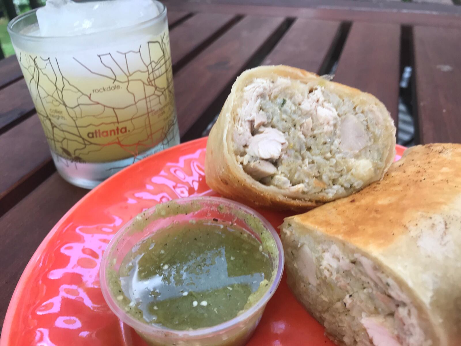 An order of a chicken burrito holds up well to travel. Pair it with a tropical Porch Pounder cocktail (left), featuring multiple rums with pineapple juice. LIGAYA FIGUERAS/LIGAYA.FIGUERAS@AJC.COM