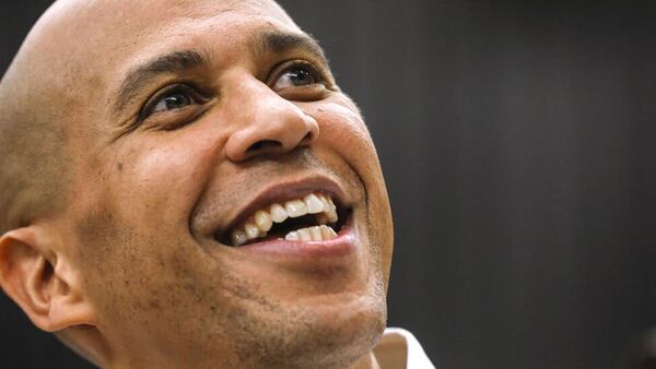 FILE - In this Oct. 28, 2018, file photo, Sen. Cory Booker, D-N.J., looks up as he takes a selfie with an attendee after speaking attends at a get out the vote event hosted by the NH Young Democrats at the University of New Hampshire in Durham, N.H.