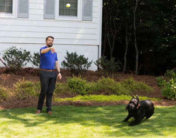 Jack Debussey throws a tennis ball for his dog Fritz. Fritz went to an intensive dog training program as a pup, which has been beneficial to the Debussey family.  (Michael Blackshire/Michael.blackshire@ajc.com)