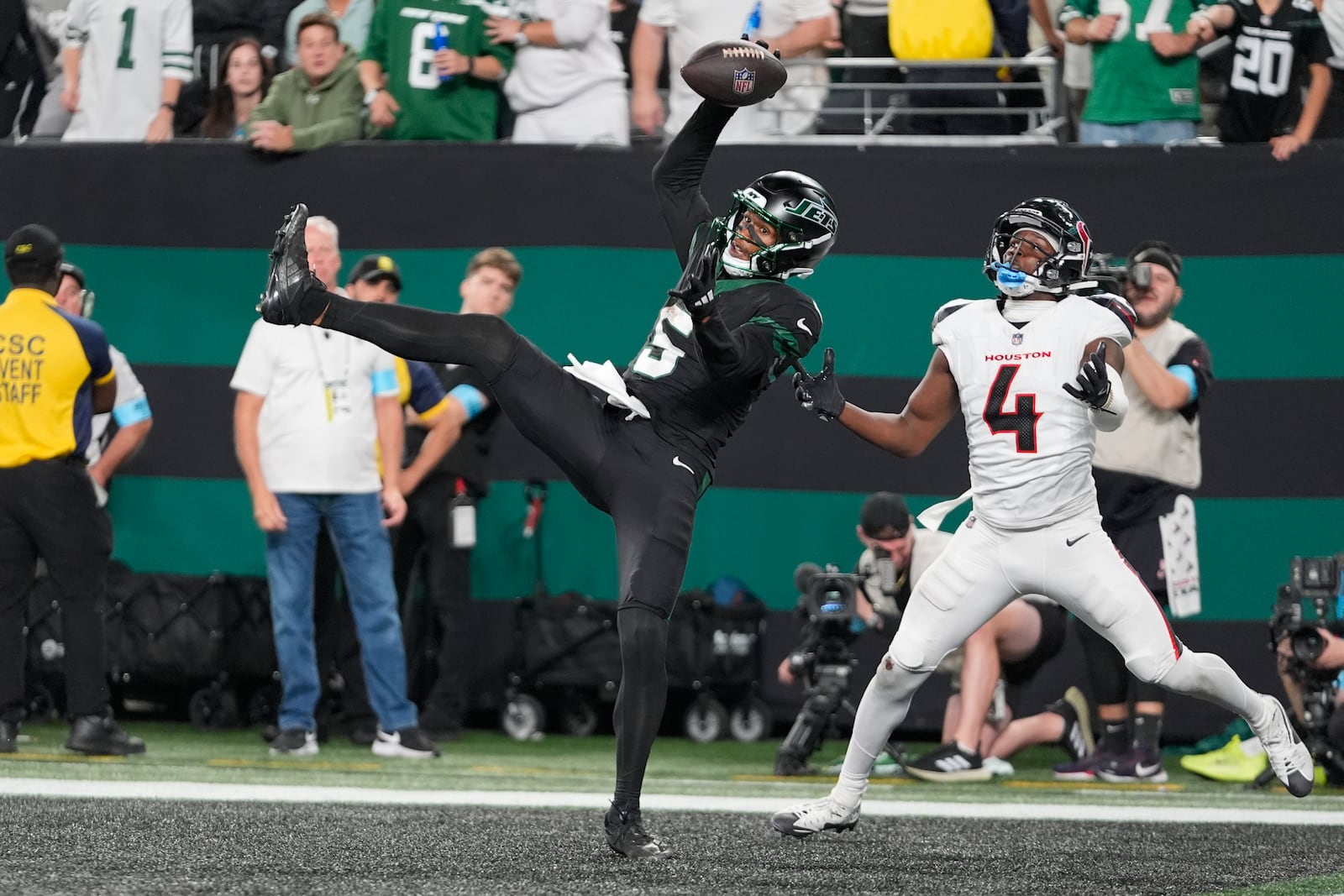 New York Jets wide receiver Garrett Wilson (5) catches a pass for a touchdown as Houston Texans cornerback Kamari Lassiter (4) defends during the second half of an NFL football game Thursday, Oct. 31, 2024, in East Rutherford, N.J. (AP Photo/Seth Wenig)