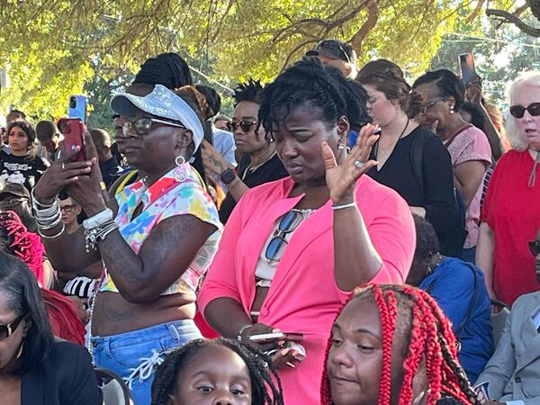 A woman holds her hand up during a prayer at the vigil for the shooting victims in Jacksonville on Sunday, August 27, 2023.