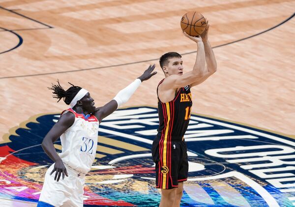 Atlanta Hawks guard Bogdan Bogdanovic (13) shoots a three-point basket past New Orleans Pelicans forward Wenyen Gabriel (32) in the second quarter of an NBA basketball game in New Orleans, Friday, April 2, 2021. (AP Photo/Derick Hingle)