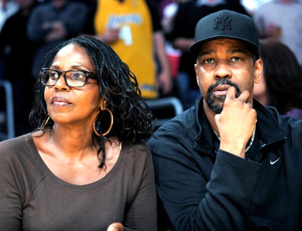 DENZEL WASHINGTON (right) and wife Pauletta watch the game. The Los Angeles Lakers finished their regular season with a 124-101 win over the Kings and clinched the No. 1 seed in the Western Conference playoffs.