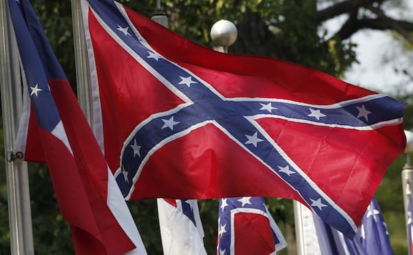 FILE - In this July 19, 2011 file photo, Confederate battle flags fly in Mountain Creek, Ala. The House has voted to ban the display of the Confederate flag on flagpoles at Veterans Administration cemeteries. The 265-159 vote would block descendants and others seeking to commemorate veterans of the Confederate States of America from flying the Confederate Battle Flag over mass graves, even on days that flag displays are permitted. (AP Photo/Dave Martin, File)