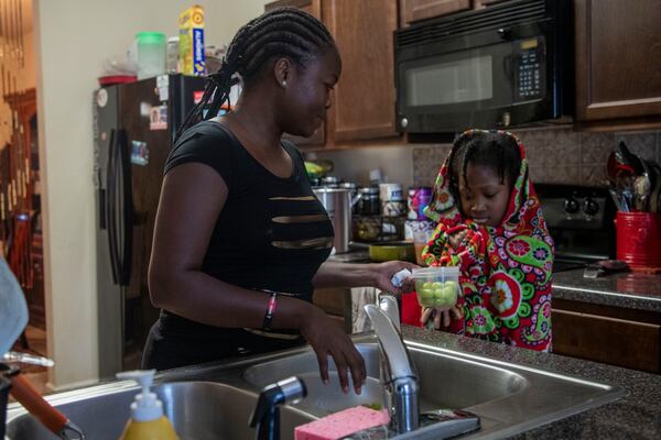 10/12/2020 - Hampton, Georgia - Mapillar Dahn gives her daughter Hajar Tyler, 11, a snack during her virtual learning at Eddie White Academy at their residence in Hampton, Monday, October 12, 2020.  (Alyssa Pointer / Alyssa.Pointer@ajc.com)