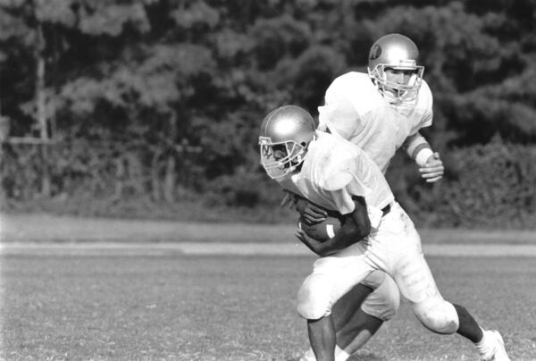 Brian Ellis, right, hands off to tailback Danny Williams in this February 1989 photo. Ellis was a 1989 graduate of Morrow High in Clayton County, where he was a star quarterback. He then graduated from the U.S. Naval Academy in Annapolis, Maryland in 1993. (Kenneth Walker/AJC archive at GSU Library AJCP25-042c)