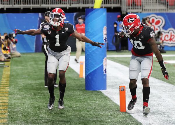 Georgia wide receiver George Pickens (left) celebrates his touchdown reception with teammate Kearis Jackson during the first quarter of the Chick-fil-A Peach Bowl against Cincinnati Friday, Jan. 1, 2021, at Mercedes-Benz Stadium in Atlanta. Georgia beat Cincinnati 24-21.     (Curtis Compton / Curtis.Compton@ajc.com)