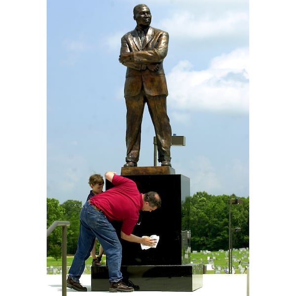 Sculptor Erik Blome wipes down the Martin Luther King Jr. statue during the statue's original installation in 2003. The sculpture was removed and then reinstalled years later. (Jason Ivester / Rocky Mount Telegram)