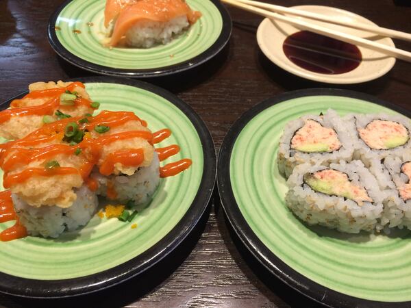  The Spicy Popcorn Shrimp Roll and the Real Crab California Roll are among the options at Kula Revolving Sushi Bar in Doraville. In the back is the Garlic Ponzu Salmon Nigiri. PHOTO CREDIT: Wendell Brock