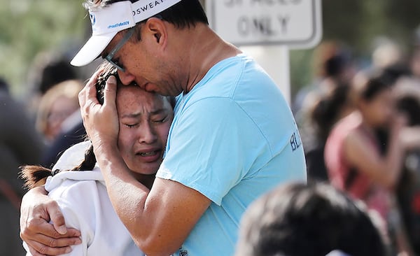 A father hugs his daughter after being reunited at a park near Saugus High School after the shooting.