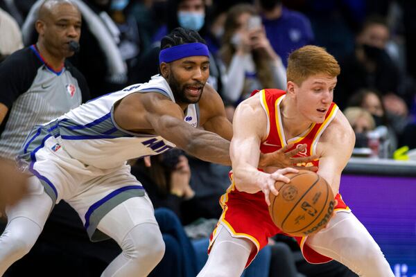 Atlanta Hawks guard Kevin Huerter, right, fouled by Sacramento Kings forward Maurice Harkless late in the second half of an NBA basketball game in Sacramento, Calif., Wednesday, Jan. 5, 2022. The Hawks won 108-102. (AP Photo/José Luis Villegas)