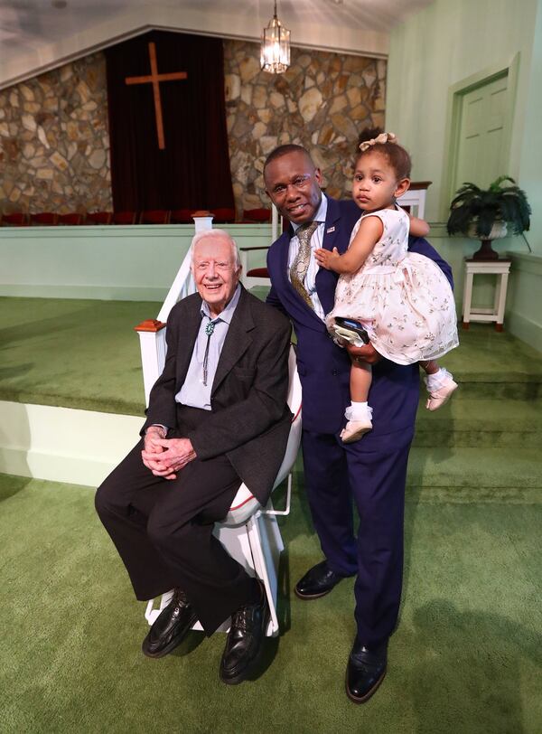 June 9, 2019 Plains: Reverend Tony Lowden holds his daughter Tabitha in the sanctuary of Maranatha Baptist Church greeting visitors with President Jimmy Carter after leading the worship service on Sunday, June 9, 2019, in Plains. Curtis Compton/ccompton@ajc.com