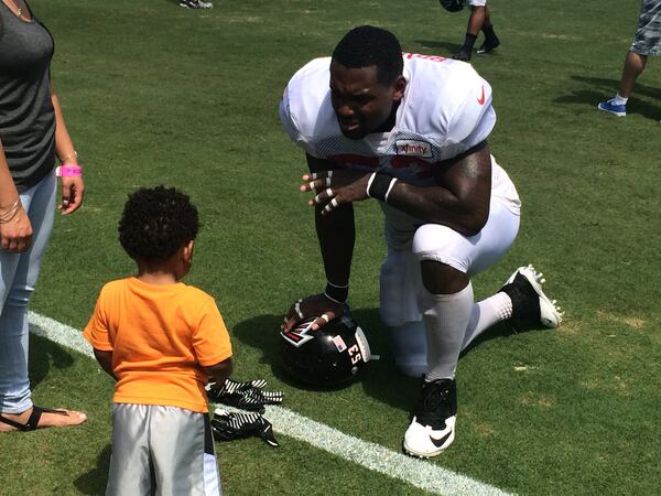 Falcons linebacker Allen Bradford with his 1-year-old son Aiden after practice on Tuesday, August 11, 2105 (By D. Orlando Ledbetter/dledbetter@ajc.com)