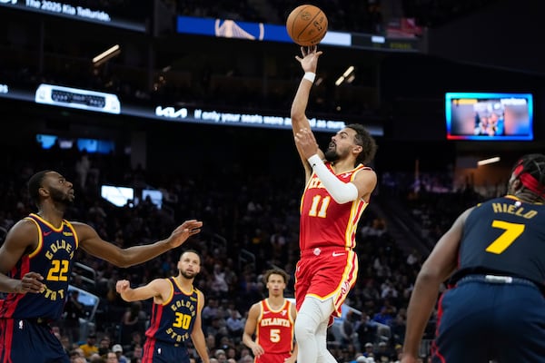 Atlanta Hawks guard Trae Young (11) shoots in front of Golden State Warriors forward Andrew Wiggins (22) during the first half of an NBA basketball game Wednesday, Nov. 20, 2024, in San Francisco. (AP Photo/Godofredo A. Vásquez)