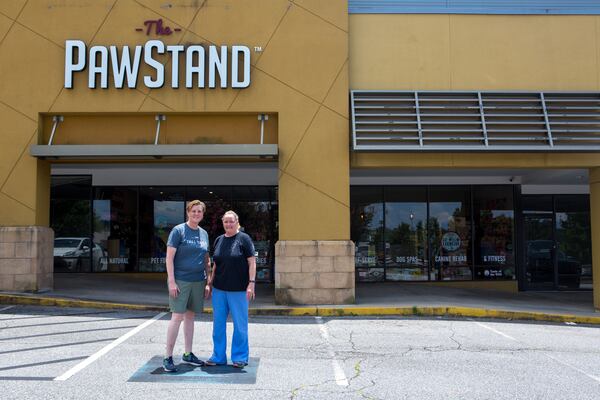 Co-owners Donna Raney (left) and Jennifer Andreae stand in front of their business, The PawStand, in Doraville. They had concerns that the parking spaces directly outside their store could be taken away following the development at the center. (Casey Sykes for The Atlanta Journal-Constitution)