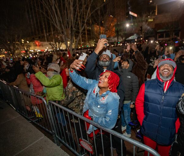 After the peach dropped, a fireworks show captures the audience attention, including Kevin Johnson, from right, Cortney Walker, front red hair, and Damien Howlett.  The Peach Drop returns to Underground Atlanta with a free concert including Big Boi as the headliner on Tuesday, Dec 31, 2024.  (Jenni Girtman for The Atlanta Journal-Constitution)