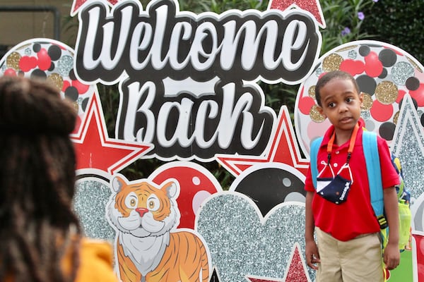 Keisha Washington takes a photo of her son Dancer on the first day of classes at Lake City Elementary School in Morrow on Aug. 3, 2021. (Steve Schaefer for the Atlanta Journal-Constitution)