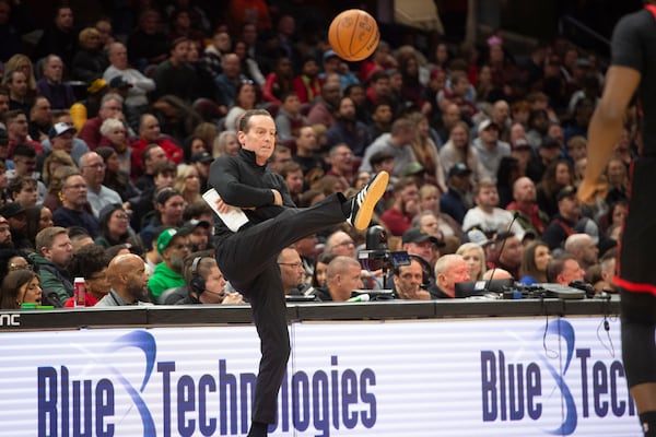 Cleveland Cavaliers head coach Kenny Atkinson gives an out of bounds ball a soccer type kick during the second half of an NBA basketball game against the Toronto Raptors in Cleveland, Sunday, Nov 24, 2024. (AP Photo/Phil Long)