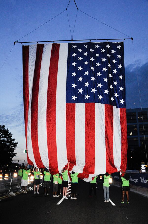 Volunteers at The Atlanta Journal-Constitution Peachtree Road Race help hang the American flag. (Courtesy of Atlanta Track Club)