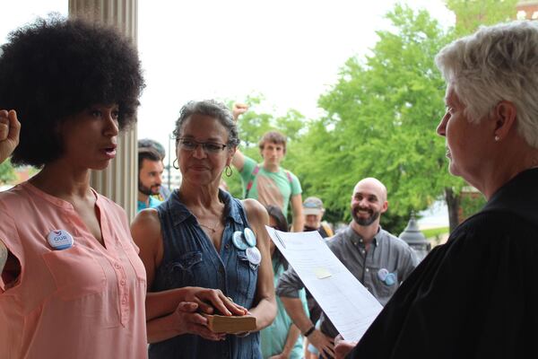 Mariah Parker is sworn in on Monday as an Athens-Clarke County commissioner while putting her hand over "The Autobiography of Malcolm X." (Raphaëla Alemán)