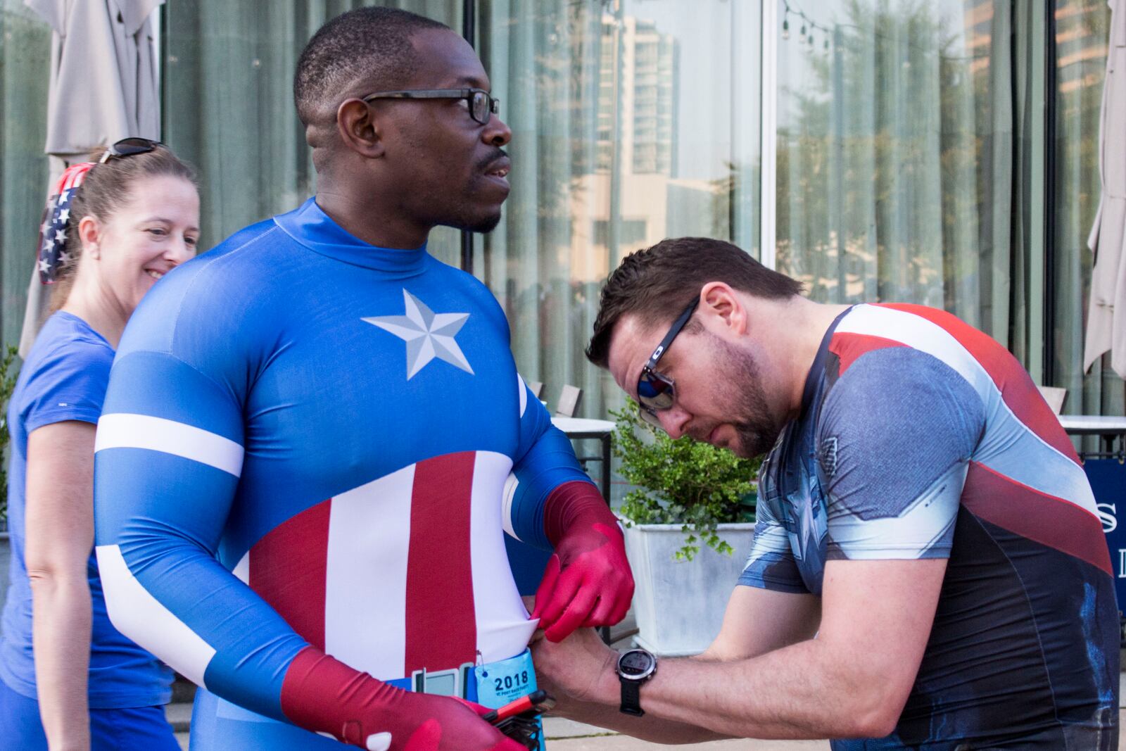 7/3/18 - Atlanta - Jamey Holt helps Byronn Howell pin his bib on his Captain America costume at the annual AJC Peachtree Road Race on Wednesday, July 4. Jenna Eason / Jenna.Eason@coxinc.com