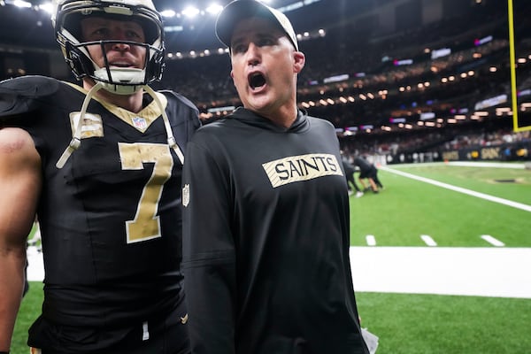 New Orleans Saints interim head coach Darren Rizzi walks off the field with tight end Taysom Hill (7) at the end of the first half of an NFL football game against the Atlanta Falcons in New Orleans, Sunday, Nov. 10, 2024. The Saints won 20-17. (AP Photo/Gerald Herbert)