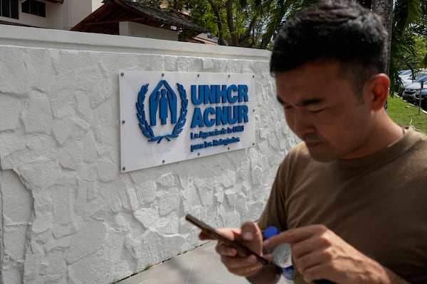 Hayatullah Omagh, an Afghan migrant who was deported from the U.S., looks at his phone at the United Nations Refugee Agency office he visited seeking advice on how and where to seek asylum in Panama City, Thursday, March 20, 2025. (AP Photo/Matias Delacroix)