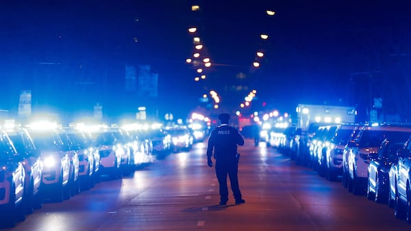 A Chicago police officer stands on the street after the procession carrying the bodies of Chicago police officers Eduardo Marmolejo and Conrad Gary arrive at the medical examiner's office early Tuesday morning, Dec. 18, 2018. The officers were struck and killed Monday evening by a train as they investigated a shots-fired call on the city’s South Side.