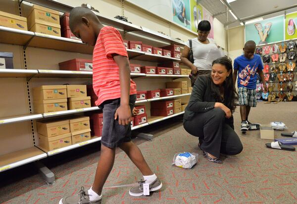 Along with running wiht the Jackson High track team and working out with the Grady football team, APS school chief Meria Carstarphen went back-to-school shopping with an APS family. Also on her agenda, preventing stake takeover of her schools. HYOSUB SHIN / HSHIN@AJC.COM