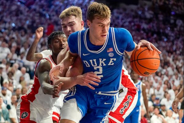 Duke guard Cooper Flagg (2) pulls down a rebound against Arizona guard Jaden Bradley, left, and Motiejus Krivas, middle, during the first half of an NCAA college basketball game Friday, Nov. 22, 2024, in Tucson, Ariz. (AP Photo/Darryl Webb)