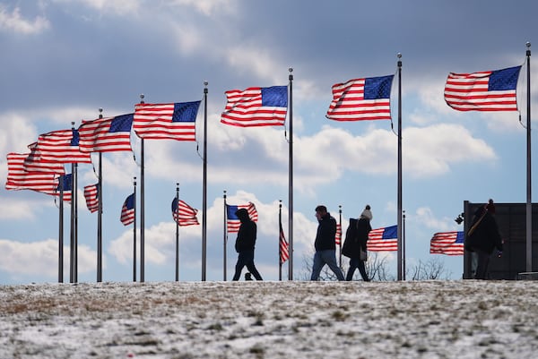 U.S. flags around the Washington Monument are at full staff during the 60th Presidential Inauguration, Monday, Jan. 20, 2025, in Washington. Flags were supposed to fly at half-staff through the end of January out of respect for former President Jimmy Carter, who died Dec. 29, 2024 They will be returned to half-staff Tuesday under Trump's order. (AP Photo/Julio Cortez)