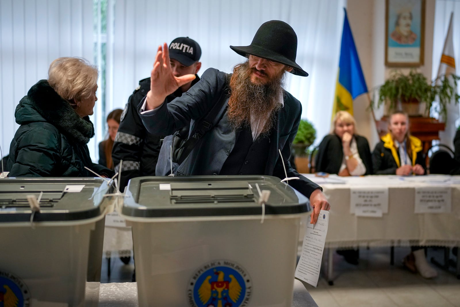 A man gestures after casting his vote in Chisinau, Moldova, Sunday, Oct. 20, 2024, during a presidential election and a referendum on whether to enshrine in the Constitution the country's path to European Union membership. (AP Photo/Vadim Ghirda)