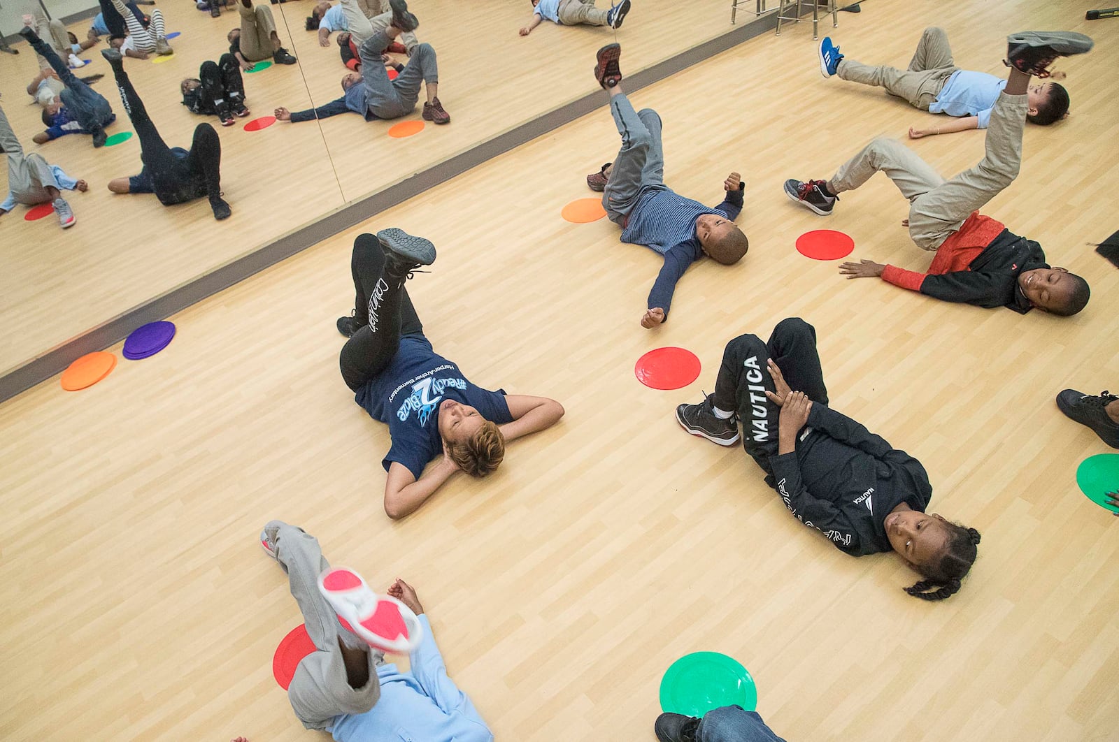 Harper-Archer Elementary School dance teacher Lisa Perrymond (front row, left) stretches with a group of second grade students at the start of dance class, Tuesday, January 28, 2020. (ALYSSA POINTER/ALYSSA.POINTER@AJC.COM)