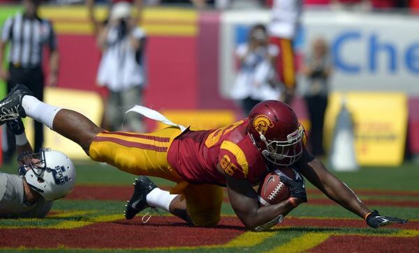 Southern California tight end Xavier Grimble, right, falls into the end zone for a touchdown as Utah State safety Brian Suite defends during the first half of an NCAA college football game on Saturday, Sept. 21, 2013, in Los Angeles. (AP Photo/Mark J. Terrill) ** Usable by LA and DC Only ** USC tight end Xavier Grimble lands in the end zone to score on a 30-yard pass play from Cody Kessler in the second quarter Saturday at the Coliseum. ( Mark J. Terrill / Associated Press / September 21, 2013 )