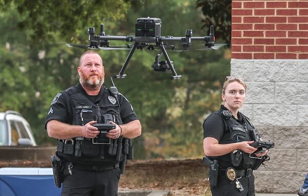 Investigators use a drone to capture aerial footage of a crime scene after a man was shot and killed by Conyers police at a gas station.