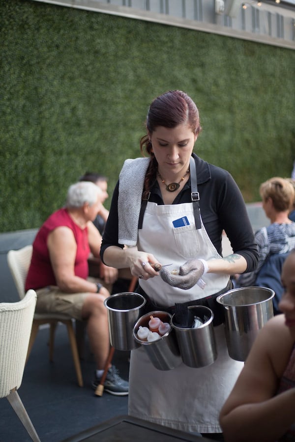 A server at Oysters Co in Atlanta shucks an oyster on the spot. PHOTO CREDIT: KayteeRuth Photography