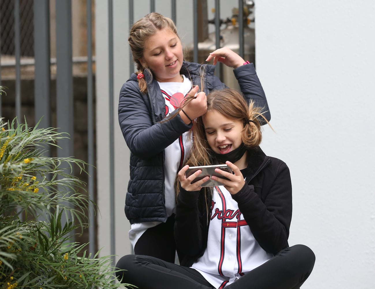 Abby Woodard, 11, does the hair of Carlson Neece, 10, both of Sandy Springs, before the Braves' World Series parade in Atlanta, Georgia, on Friday, Nov. 5, 2021. (Photo/Austin Steele for the Atlanta Journal Constitution)