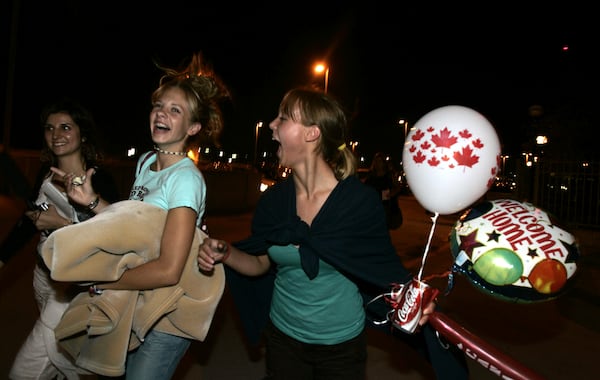 FILE - Heather Langille, left and Lauren Langille, right, of Oshawa celebrate their safe arrival in the airport parking lot after the Airbus A340 plane they were passengers on slid off the runway and crashed at Toronto Pearson International Airport in Toronto, Tuesday, Aug. 2, 2005. The woman at far left is unidentified. (AP Photo/David Duprey, File)