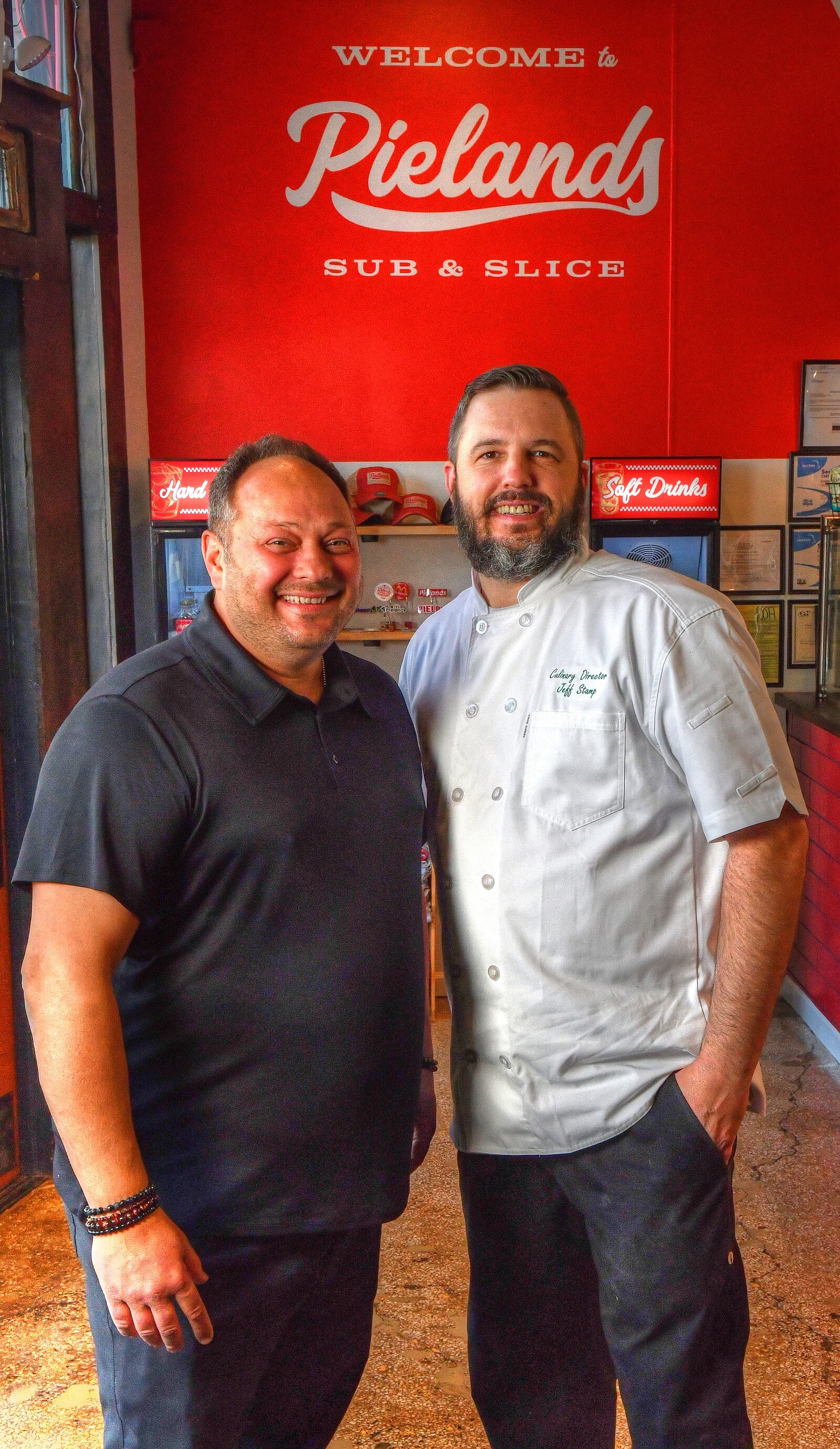 Pielands Sub & Slice owner Billy Streck (left) and culinary director Jeff Stamp pose for a team photo. Both came from families in New York state with pizza places. (Chris Hunt for The Atlanta Journal-Constitution)