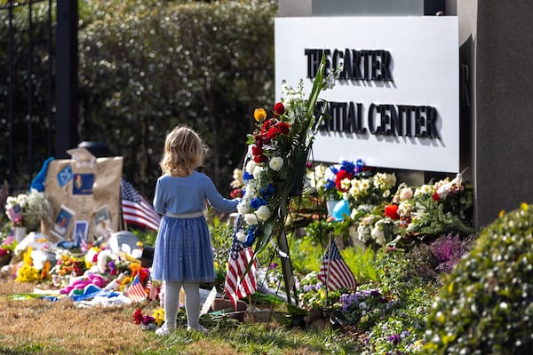 A girl stands by the memorial outside the Carter Center in Atlanta on Sunday.