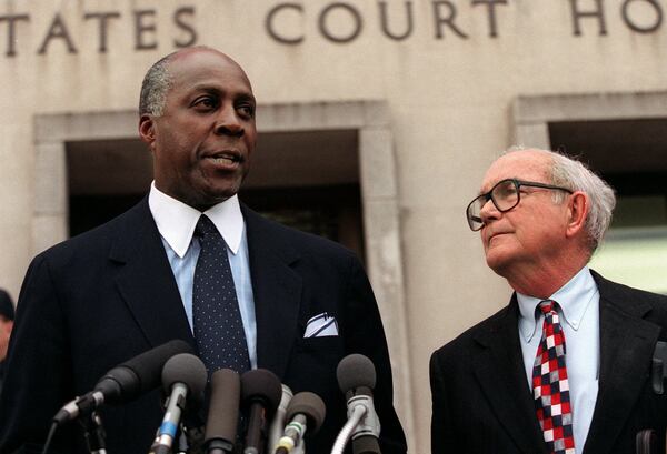 Vernon Jordan, accompanied by attorney William Hundley, meets with reporters outside federal court in Washington in 1998. 