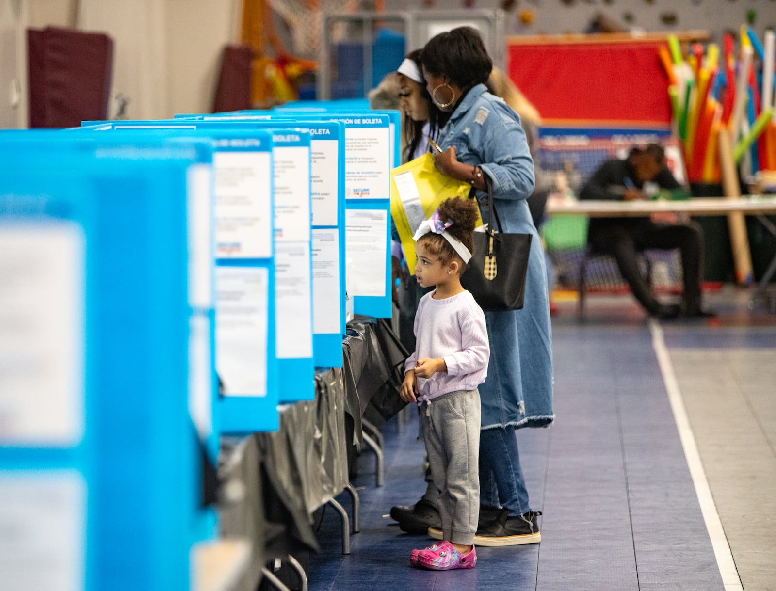 Gwinnett County voter Alyssa Alvaranga cast her ballot in Dacula on Tuesday, with support from 4-year-old daughter Leilani.